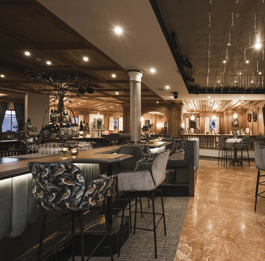 Elegante Bar mit luxuriösem Interieur und modernen Sitzgelegenheiten in einem stilvoll beleuchteten Raum.