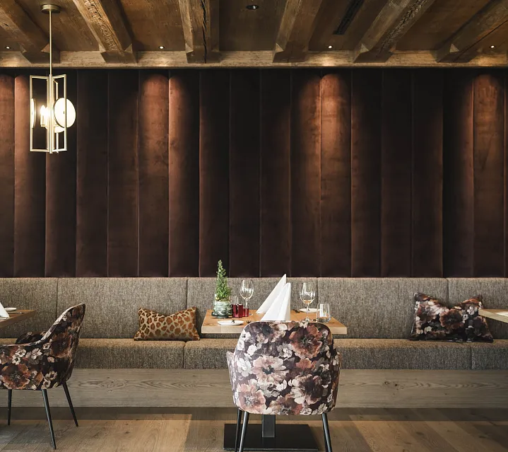 Elegantes Restaurantinterieur mit gepolsterten Sitzbänken und stilvollen Hängelampen.