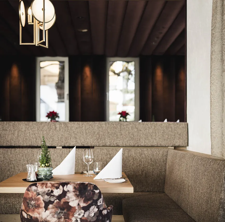 Modernes Restaurantinterieur mit gedecktem Tisch und Dekoration auf Sitzbank.