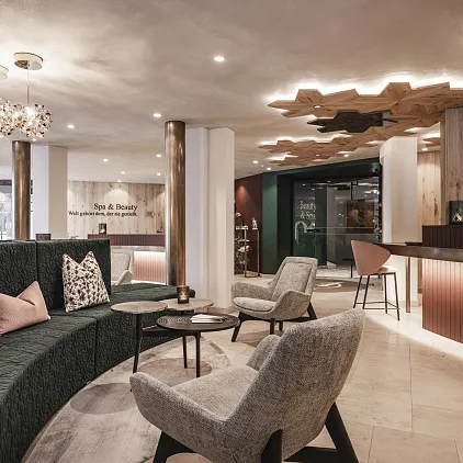 Moderne Hotellobby mit stilvollen Sitzgelegenheiten und eleganter Beleuchtung in warmem Ambiente.