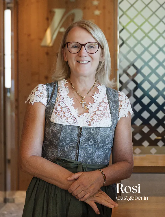 Person in traditioneller Tiroler Tracht in einem modern gestalteten Innenraum.