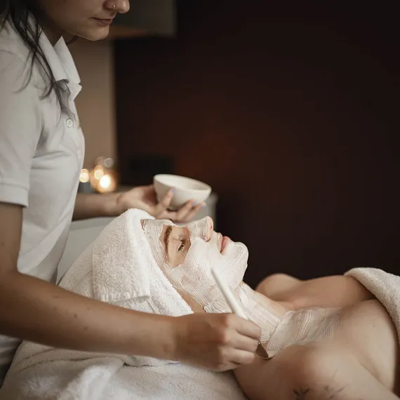 Person erhält Gesichtsbehandlung in einem Wellnesszentrum.