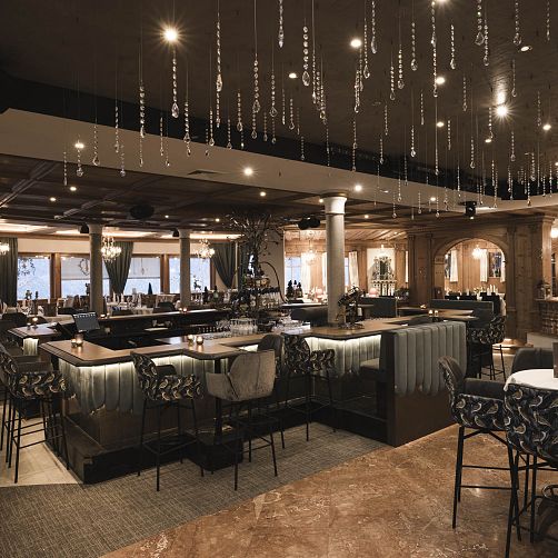 Elegantes Restaurantinterieur mit Kronleuchter und Polstermöbeln in gedämpften Beleuchtung.