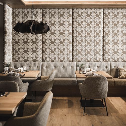 Elegantes Restaurantinterieur mit gepolsterten Stühlen, Holztischen und dekorativer Wandverkleidung.