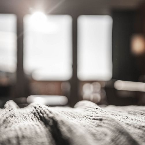 Unscharfer Innenraum mit Licht, das durch große Fenster fällt.