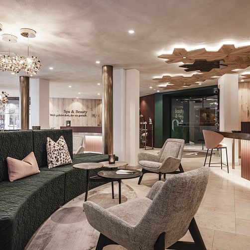 Modernes Hotellobby-Interieur mit stilvollen Sitzgelegenheiten und holzverzierter Decke in Tirol.