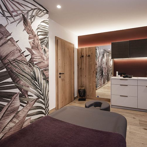 Modern eingerichteter Innenraum mit Holzdetails und Pflanzenmuster-Tapete.