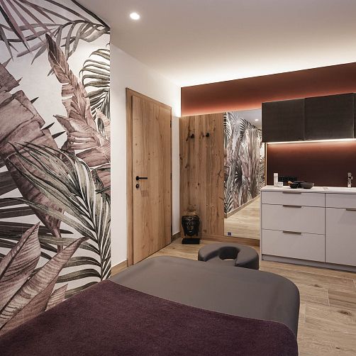 Modern eingerichteter Raum mit Holzdetails, großem Spiegel und tropischen Wandtapeten.