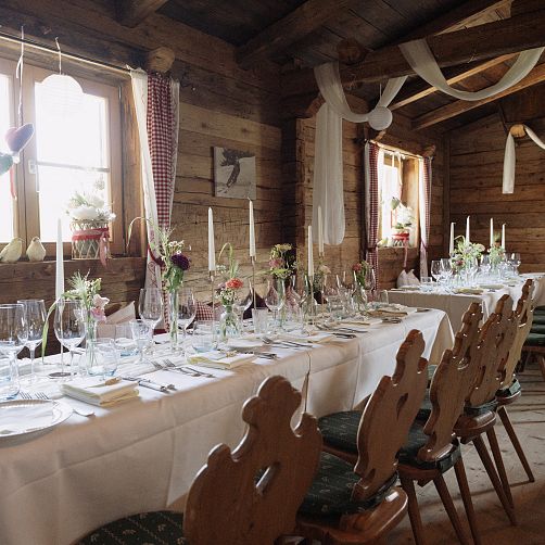 Rustikale Holzhütte mit festlich gedecktem Tisch für ein Event.