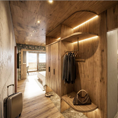 Hotelzimmer mit Holzmöbeln, offenem Kleiderschrank, Fenster mit Balkonblick und Koffer am Boden.